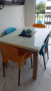 uma mesa numa sala com cadeiras à volta em Apartamento Flandes em Flandes
