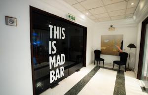 Ein Ladenfenster mit einem Schild, auf dem steht, dass das eine verrückte Bar ist. in der Unterkunft BTH Hotel Lima Golf in Lima