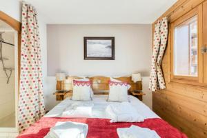 ein Schlafzimmer mit einem Bett mit roten und weißen Kissen in der Unterkunft Résidence Les Fermes du Soleil - maeva Home - Appartement 3 Pièces 6 Personnes - Sélection MAE-6505 in Les Carroz d'Araches + 20 Fotos