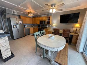 a kitchen with a table with chairs and a refrigerator at Paradise PRN in Gulf Shores