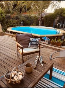 eine Holzterrasse mit einem Stuhl neben einem Pool in der Unterkunft Les trois îles O.Ré.A. in Aytré