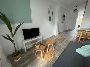 sala de estar con sofá, mesa y planta en LE NID - Charmante petite maison avec balnéo, en Gambais