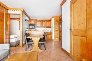 a kitchen and dining room with a table and chairs at Résidence Les Hauts Bois - maeva Home - Appartement 3 Pièces 6 Personnes - 11 in Aime-La Plagne