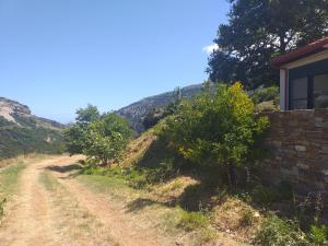 a dirt road next to a house on a hill at Aiolida in Karistos