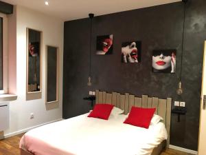 a bedroom with a bed with two red pillows at Charles sous le Charme in Nancy
