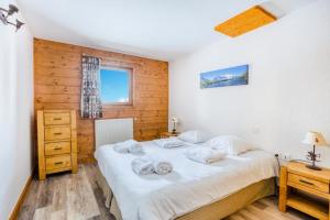 a bedroom with a bed and a wooden wall at Résidence Les Alpages de Chantel - maeva Home - Appartement 2 pièces 6 personn in Bourg-Saint-Maurice