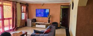 a living room with a couch and a flat screen tv at Weavers Haven in Naivasha