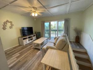 een woonkamer met een bank en een plafondventilator bij Paradise PRN in Gulf Shores