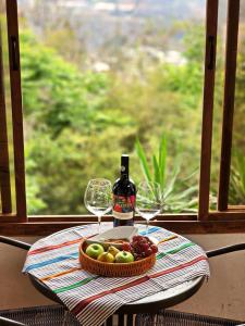 una mesa con una bandeja de fruta y una botella de vino en CABAÑAS EN ZONA 16 en Guatemala