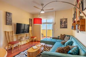a living room with a blue couch and a tv at Mirador del Ocaso in La Zubia