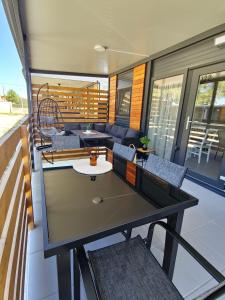 una casa con balcón con mesa y sillas en Mobile home Sara en Privlaka