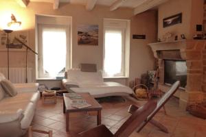 ein Wohnzimmer mit einem Sofa und einem Kamin in der Unterkunft Maison de charme au centre-ville d'Etel in Étel