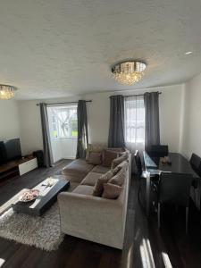 Frobisher Apartment في Erith: غرفة معيشة مع أريكة وطاولة