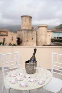 a bottle of wine sitting on a table with two chairs at Corso Italia Luxury Suite in Fondi
