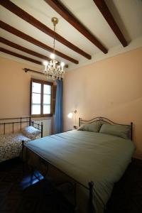 una camera da letto con un grande letto e un lampadario a braccio di LE VOLTE centro storico di Poppi a Poppi