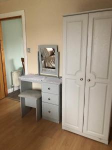 a room with a desk with a mirror and a cabinet at Riverside in Doonbeg