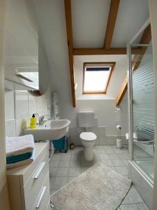 a bathroom with a sink toilet and a window at Ferienwohnung Leonardo in Badem