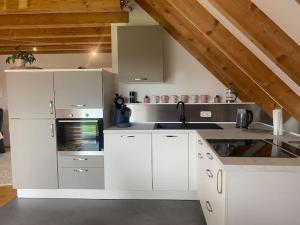 a kitchen with white cabinets and a stove top oven at Ferienwohnung Leonardo in Badem