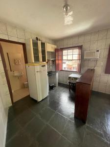 Una cocina con un refrigerador y una mesa dentro. en Suíte da vovó, en Ouro Preto