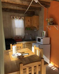 a kitchen with a table with chairs and a microwave at Solanas de Uspallata in Uspallata