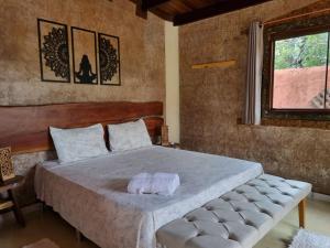 a bedroom with a large bed and a window at Free Soul House - Localização ideal no centrinho in Alto Paraíso de Goiás
