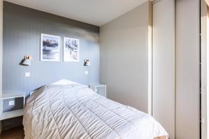 Résidence Le Thabor - maeva Home - Appartement 3 Pièces 6 Personnes - Pres 204 في Le Désert: غرفة نوم بسرير وصورتين على الحائط