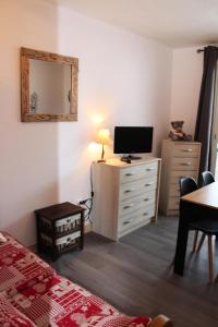 een slaapkamer met een bed en een dressoir met een televisie bij Résidence Les Issarts - 2 Pièces pour 4 Personnes 761 in Le Dévoluy