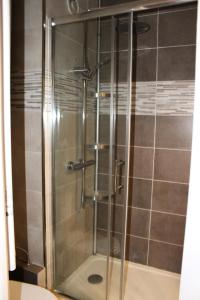 La salle de bains est pourvue d'une douche avec une porte en verre. dans l'établissement Résidence Les Issarts - 2 Pièces pour 4 Personnes 761, à Saint-Étienne-en-Dévoluy