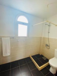 a bathroom with a toilet and a window at Tamra Residence Apartment Families and Couples Only in Sharm El Sheikh