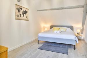 1 dormitorio con 1 cama blanca en una habitación en Duplex tout confort sur la Route des Vins dans un village typique et médiéval - Appartements 3 et 4 personnes - Centre Alsace en Bergheim