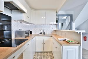 a kitchen with white cabinets and a sink at Duplex tout confort sur la Route des Vins dans un village typique et médiéval - Appartements 3 et 4 personnes - Centre Alsace in Bergheim