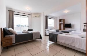Habitación de hotel con 2 camas y TV en Praia Comprida Hotel, en São José