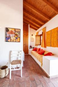 a bedroom with a bed and a chair in a room at Casa Bene Holiday Home in Aljezur
