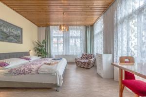 a bedroom with a bed and a chair and windows at Penzion Pokorny in Jablonec nad Nisou