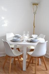 a white dining room table with white chairs and a lamp at Unique and luxury city center apartment with free parking in Southampton