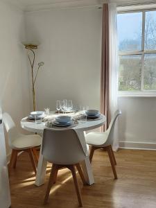 a white dining room table with white chairs and a window at Unique and luxury city center apartment with free parking in Southampton