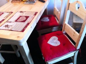 a table with two chairs with red cushions at Résidence Le Hameau du Sauget - maeva Home - Appartement 2 pièces 6 person 334 in La Plagne Tarentaise