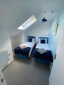 two beds in a room with blue walls at stylish and modern Spacious 2 bedroom apartment in Clodock