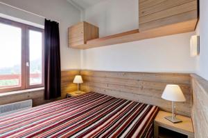 een slaapkamer met een groot bed en een raam bij Résidence Le Britania - maeva Home - Appartement 2 pièces 4 personnes - Pr 534 in Saint-Bon-Tarentaise