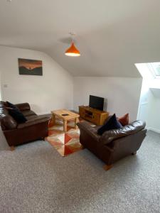 a living room with two leather couches and a table at stylish and modern Spacious 2 bedroom apartment in Clodock