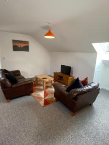 Una sala de estar con dos sofás de cuero y una mesa. en stylish and modern Spacious 2 bedroom apartment, en Clodock