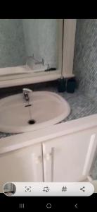 een badkamer met een witte wastafel en een spiegel bij Anse margot in Baie Nettle