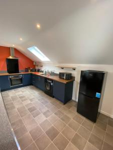 cocina con nevera negra y suelo de baldosa en stylish and modern Spacious 2 bedroom apartment, en Clodock