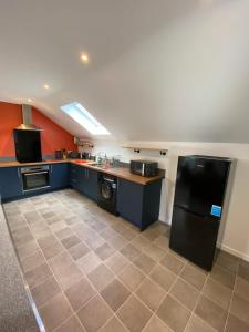 a kitchen with a black refrigerator and a tile floor at stylish and modern Spacious 2 bedroom apartment in Clodock