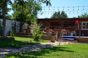 einen Hinterhof mit einem Haus mit einer Bar und Stühlen in der Unterkunft Casa La Românaș in Tuzla