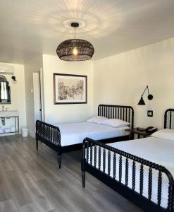 um quarto com 2 camas e um lustre em Anaheim Maingate Inn em Anaheim