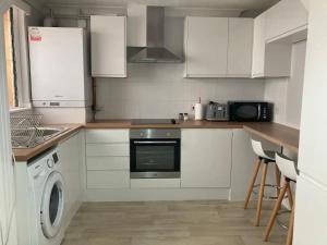 uma cozinha com armários brancos e uma máquina de lavar roupa em Southampton Lodge em Southampton