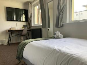Dormitorio con cama, escritorio y TV en Southampton Lodge en Southampton