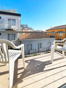 two white chairs sitting on the roof of a building at Hotel Reale in Rimini