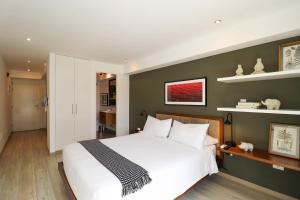 a bedroom with a white bed and a green wall at Primera Parada By Wynwood House in Lima